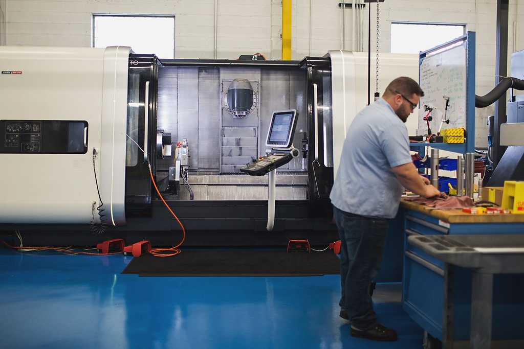A machinist working at a CNC machining center